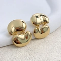 Vista macro de pendientes de frijol bañados en oro con acabado pulido de espejo - Dorado