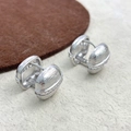 Detail van zilveren huggie-oorbellen met gestreepte textuur en witte zirkonia's - Zilver