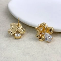 Dettaglio macro degli orecchini a fiore dorati con zircone a goccia e piccoli cristalli - Oro