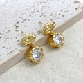 Detail of 18K gold earrings featuring fluid texture and round brilliant cut zircon stones - Gold