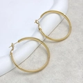 Detalle de aros grandes bañados en oro de 18K con acabado de espejo pulido brillante - Dorado