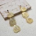 Macro shot of gold-tone tiered petal earrings with clear zircon on beige stone stand - Gold (A1401-01B)