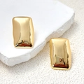 Macro shot of minimalist gold rectangular earrings on a natural textured stone surface - Gold