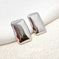 Macro shot of silver rectangular earrings with a polished liquid metal mirror finish - Silver