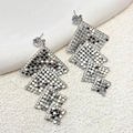 Macro shot of silver geometric mesh tassel earrings with sparkling zircon crystal stud - Silver