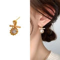Elegant gold earrings featuring a large zircon, small pearls, and a teardrop stone accent - Gold