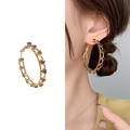 Elegant gold-tone hoop earrings with black triangular gemstones and hollowed structure - Gold