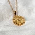 Gros plan d'un pendentif fleur en acier 304 avec détails dorés et chaîne à maillons O - Collier Doré (A1002-12B)