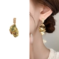 Boucles d'oreilles pétales dorées multicouches avec zircons portées par un mannequin - Doré