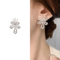 Silver bow stud earrings with twisted texture and zircon stones on a female model - Bright Silver