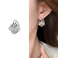 Silver woven knot earrings with sparkling cubic zirconia on a female model - Bright Silver
