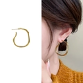 Minimalistische vergulde onregelmatige oorringen op model en in product close-up - Goud Klein