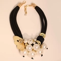 Collana con perle finte, petali dorati e cordoncino nero intrecciato stile moderno - Collana
