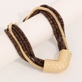 Detailweergave van de boho kralenketting met grote goudkleurige gehamerde V-vormige hanger - Bruin