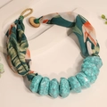 Close-up of bohemian fabric necklace with turquoise resin beads and tropical floral print - Dark Green (X-888)