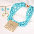 Détail d'un collier de perles turquoise à plusieurs rangs avec pendentif doré et boucles - Collier avec pendentif carré + Boucles d'oreilles