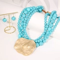 Détail du collier de perles turquoise à plusieurs rangs avec grand pendentif cœur doré - Collier avec pendentif irrégulier + Boucles d'oreilles