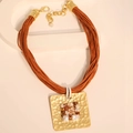 Détail d'un collier multicouches en cordon avec un pendentif carré martelé en pierre - Collier de perles
