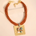 Détail d'un collier bohème avec cordons multicouches et pendentif carré en pierre - Collier Étoile de Mer