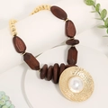 Collana boho in legno con grande ciondolo a disco dorato e perla sintetica - caffè