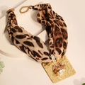 Detailed view of leopard print fabric pendant with textured gold metal and faux pearl inlay - Style 1 (Brown Leopard Print)