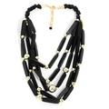 Dettaglio di una collana boho multistrato con perline nere opache e sfere dorate lucide - Nero