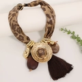 Détail du collier imprimé léopard avec disque doré et long gland marron foncé - Marron