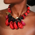 Detail of bohemian red resin statement pendant with gold metal rings on black cord - Red