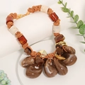 Detail of bohemian braided rope necklace with marble texture resin pendant and wood discs - Brown