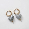 Détail de boucles d'oreilles cœur dorées avec pendentifs en résine marbrée grise - Noir et Blanc