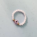 Handmade beaded elastic ring featuring light pink faceted beads and purple evil eye accent - Pink