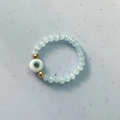Bohemian elastic bead ring featuring light blue faceted beads and a Turkish evil eye charm - Lake Blue
