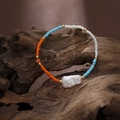 Dettaglio di perline colorate e grande perla barocca su bracciale elastico boho - Mix Arancione Blu Bianco (SB004-A)
