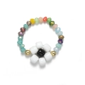 Detail of handmade beaded flower ring with colorful faceted beads and white petal design - White