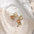 Detalle de pendientes bohemios con piedra ojo de gato naranja sobre superficie de piedra - Estilo Ojo de Gato Naranja (DE046)