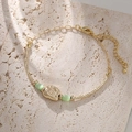 Elegant gold chain bracelet with green cat eye stones and textured metal on stone surface - Gold Cat's Eye Style (SB016)