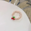 Primo piano dell'anello di perle bianche con un grazioso ciondolo a forma di ciliegia rossa - Bianco Perla