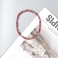 Detail of red Evil Eye glass bead stretch bracelet on minimalist magazine background - Red