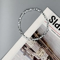 Detailed view of white Evil Eye beads with blue pupils on an elastic jewelry cord - Black & White