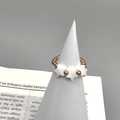 Detail view of gold beaded stretch ring featuring a natural shell star charm on cone stand - Triple Star Shell Style (DR009)