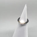 Macro view of elastic beaded ring featuring black faceted beads and a baroque pearl - Adult Size / Black