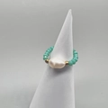 Detail view of elastic beaded ring featuring white baroque pearl and green faceted beads - Adult Size / Light Green