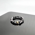 Macro detail of elastic beaded ring with blue evil eye beads and gold spacer bead - Black-Gold Accessories / One Size 17mm