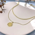 Dettaglio collana a strati dorata con pendente a ragnatela in un contenitore di ceramica - Stile Ragnatela (DN083) / Oro