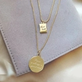 Macro-opname van 18K vergulde dubbellaagse ketting met Good Luck gegraveerde hangers - Goud