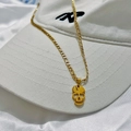 Dettaglio del ciondolo a teschio dorato in acciaio inox con catena Figaro su cappello - Collana Testa di Morto