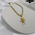 Dettaglio del ciondolo a scheletro danzante su catena Figaro su uno sfondo di raso bianco - Collana Scheletro