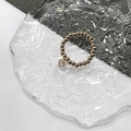 Close-up of golden beaded ring with a heart-shaped zircon pendant on glass surface - Gold - Clear Zircon