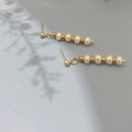 Detail of freshwater pearl tassel earrings with gold beads on a soft grey background - Pearl White (DE063)
