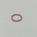 Vista macro dell'anello elastico con perline in cristalli rosa sfaccettati e sfere d'oro - Stile B Fascia Semplice